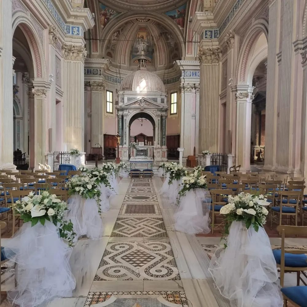 Allestimento floreale in chiesa con composizioni lungo la navata